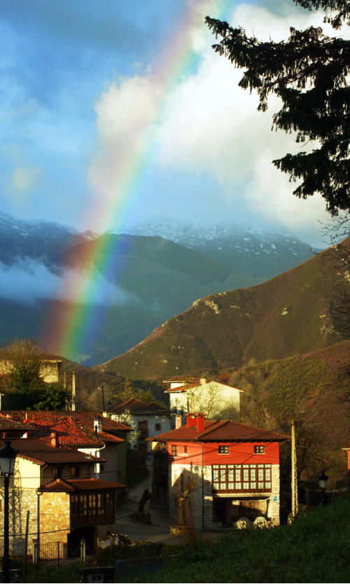 Vista exterior de los apartamentos Las Muelas con arco iris sobre los Picos de Europa