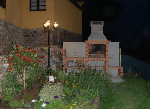 Barbacoa de obra al anochecer rodeada de flores
