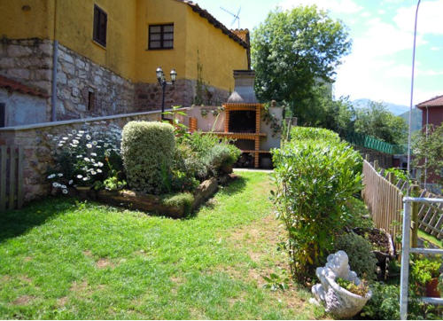 Zona ajardinada con barbacoa de los Apartamentos Las Muelas